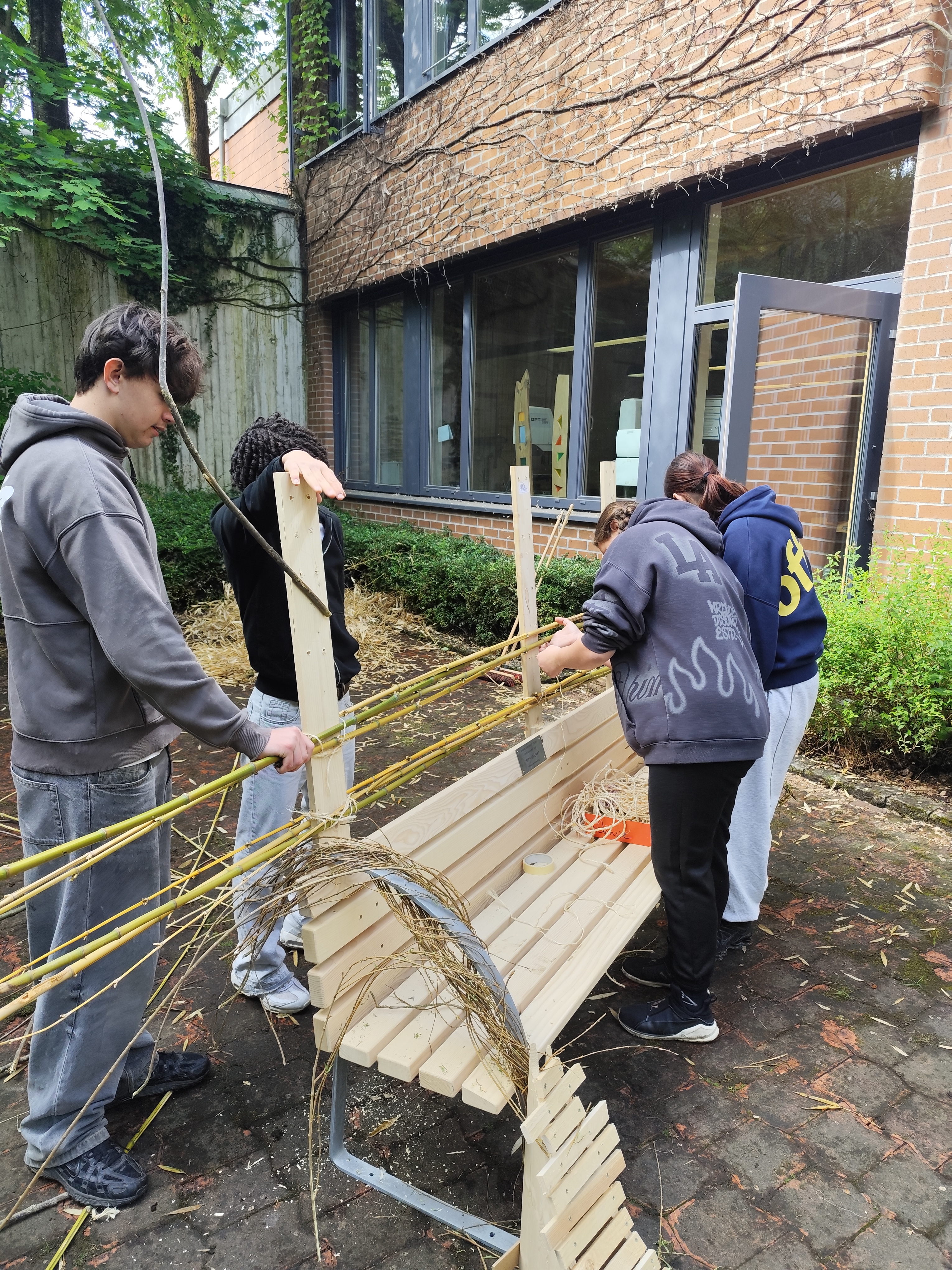 Schülerinnen und Schüler der Mittelschule Altenerding arbeiten an der Sitzbank.
